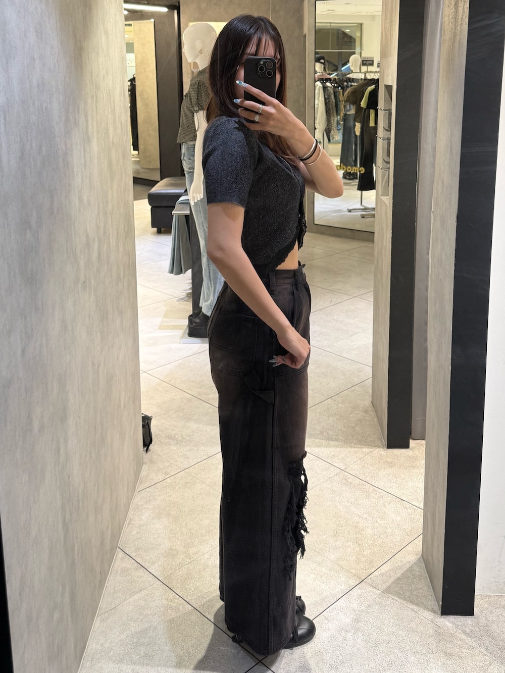 ブラック系のニット/セーター、ブラック系のデニムパンツ、ブラック系のスニーカーを着用したレディースの春コーディネートの2枚目の写真
