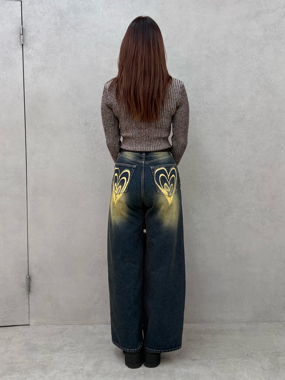 ブラウン系のニット/セーター、ブルー系のデニムパンツ、ブラック系のトートバッグを着用したレディースの冬コーディネートの3枚目の写真