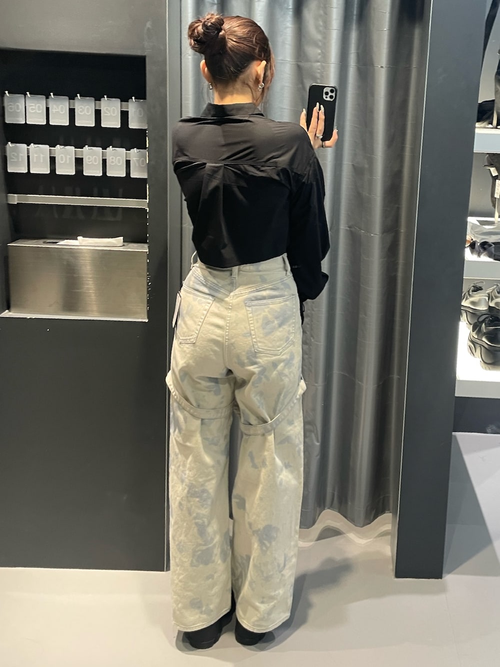 ブラック系のシャツ/ブラウス、ホワイト系のデニムパンツ、ブラック系のブーツを着用したレディースの春コーディネートの3枚目の写真