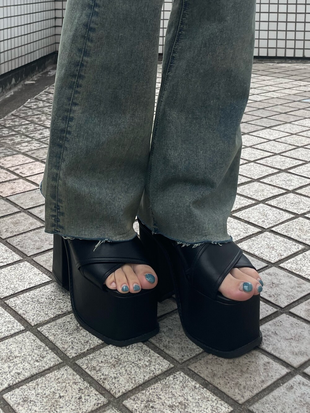 ブラック系のスカート、ブラック系のサンダル、グレー系のニット/セーターを着用したレディースの夏コーディネートの9枚目の写真