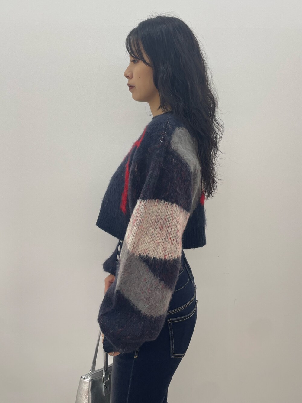 ブルー系のニット/セーター、ブルー系のデニムパンツ、ブラック系のブーツを着用したレディースの夏コーディネートの5枚目の写真