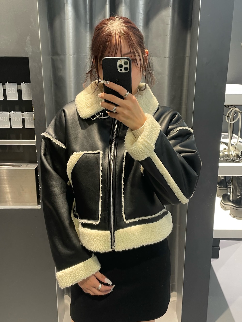 ホワイト系のニット/セーター、ブラック系のスカート、ブラック系のブルゾンを着用したレディースの冬コーディネートの4枚目の写真