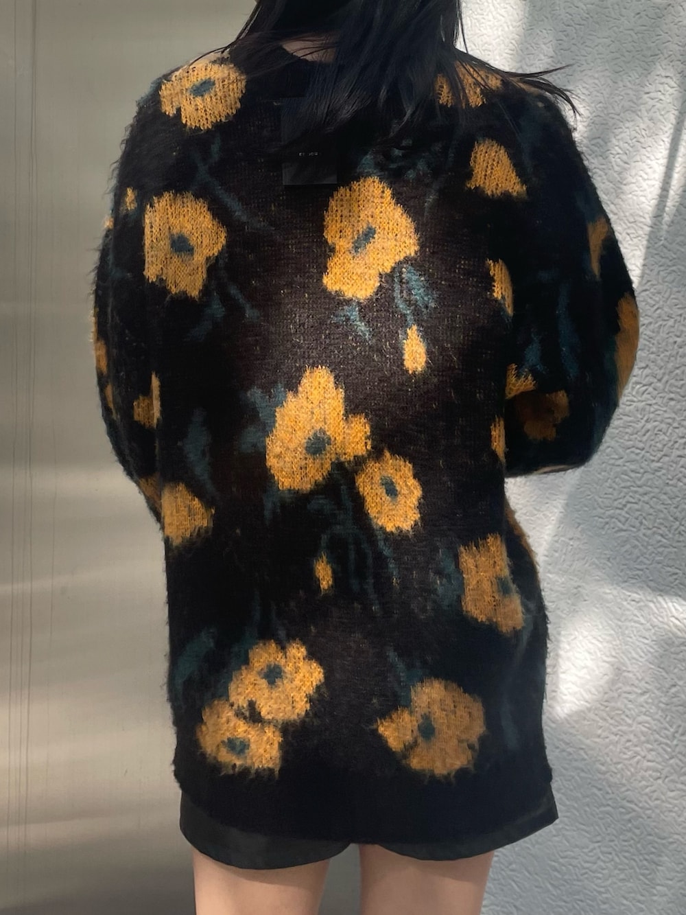 オレンジ系のニット/セーター、ブラック系のムートンコート、ブラック系のその他パンツを着用したレディースの秋コーディネートの7枚目の写真