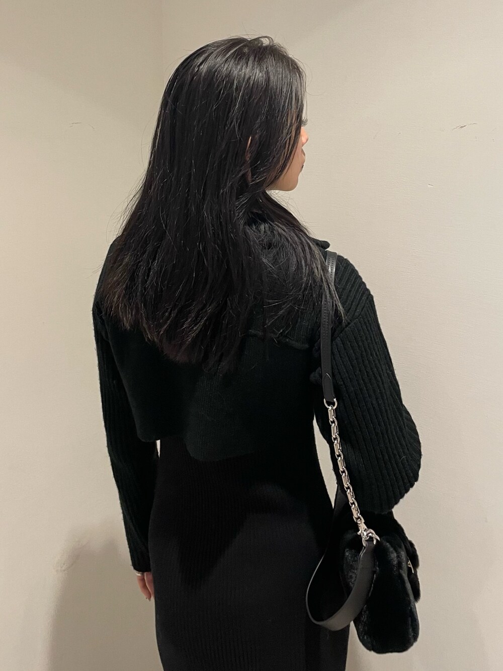 ブラック系のワンピース、ブラック系のハンドバッグ、ブラック系のブーツを着用したレディースの秋コーディネートの5枚目の写真