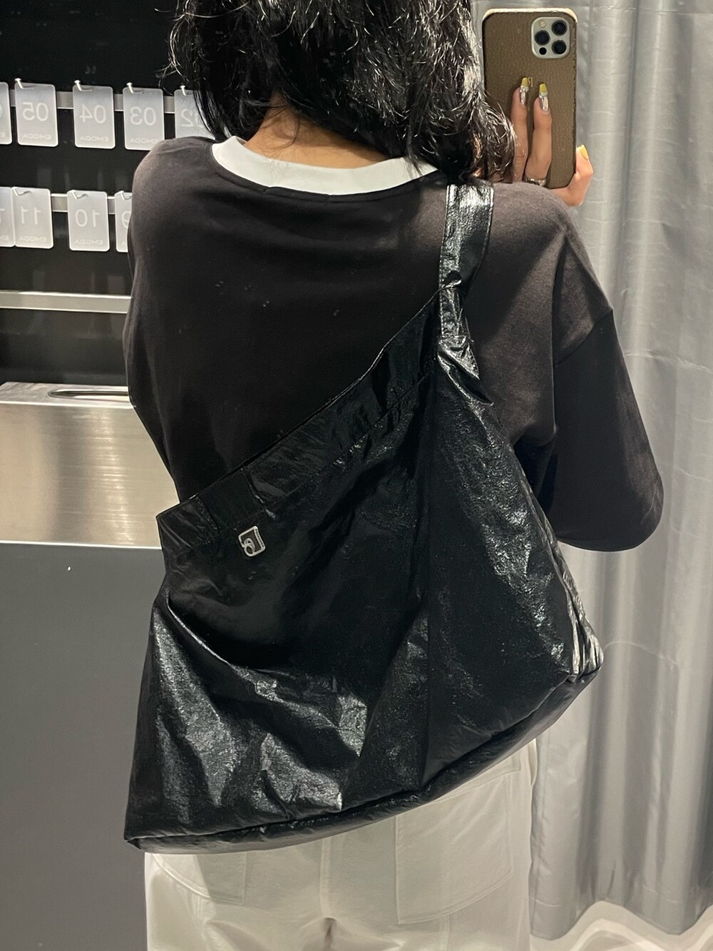 ブラック系のTシャツ/カットソー、ブラック系のハンドバッグ、ホワイト系のカーゴパンツを着用したレディースの春コーディネートの8枚目の写真