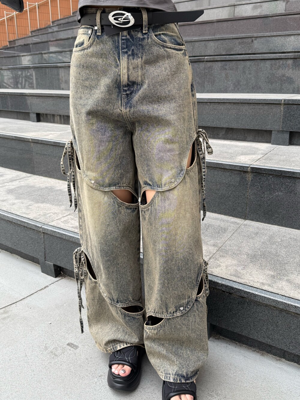 ブラック系のニット/セーター、ブルー系のデニムパンツ、ブラック系のサンダルを着用したレディースの夏コーディネートの7枚目の写真