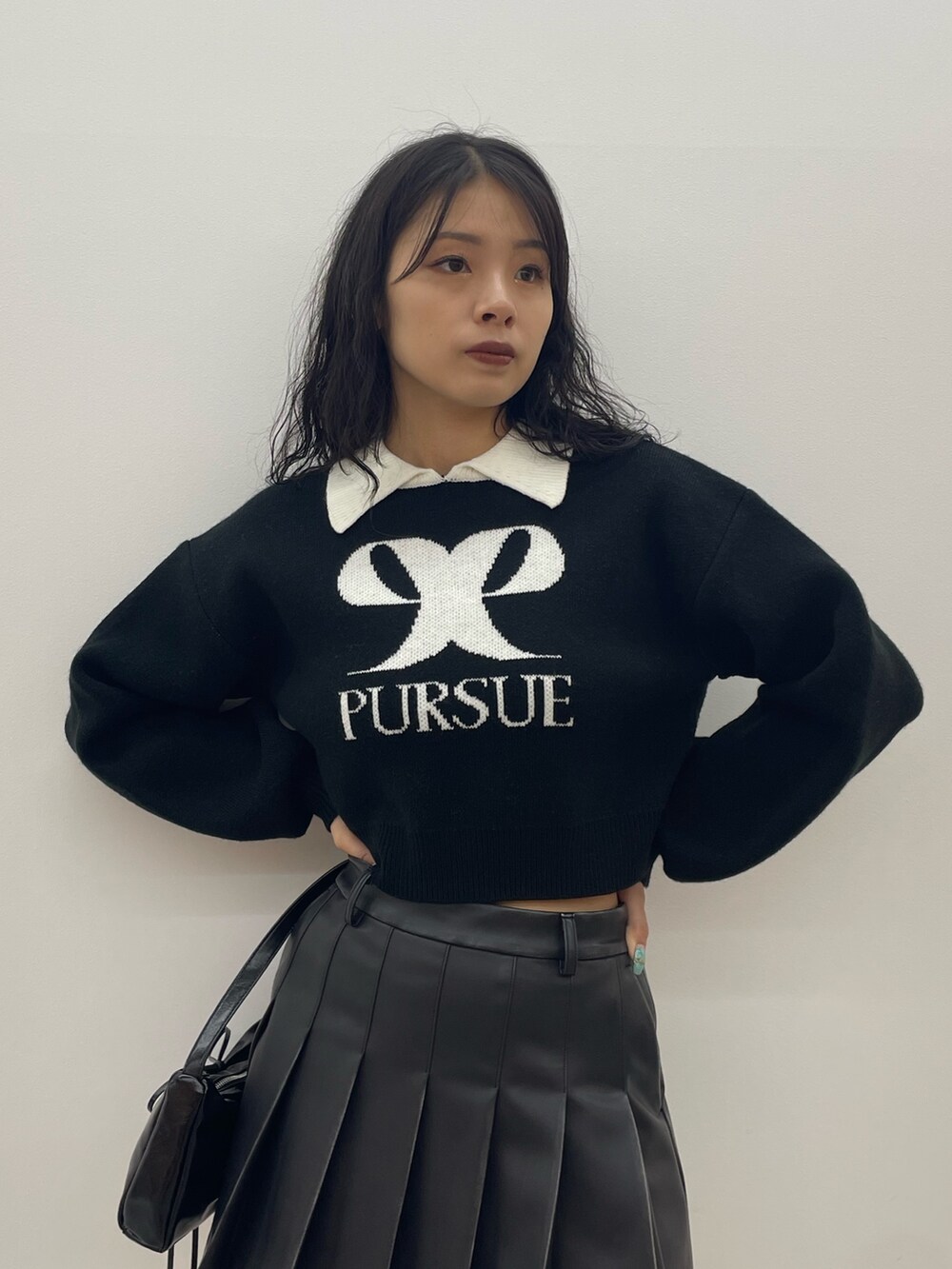 ブラック系のニット/セーター、ブルー系のデニムパンツ、ブラック系のショルダーバッグを着用したレディースの夏コーディネートの4枚目の写真
