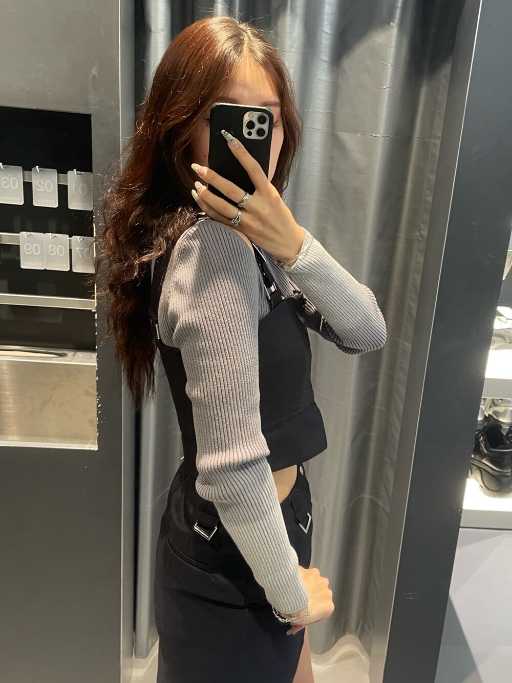 グレー系のニット/セーター、ブルー系のスカート、シルバー系のスニーカーを着用したレディースの冬コーディネートの5枚目の写真