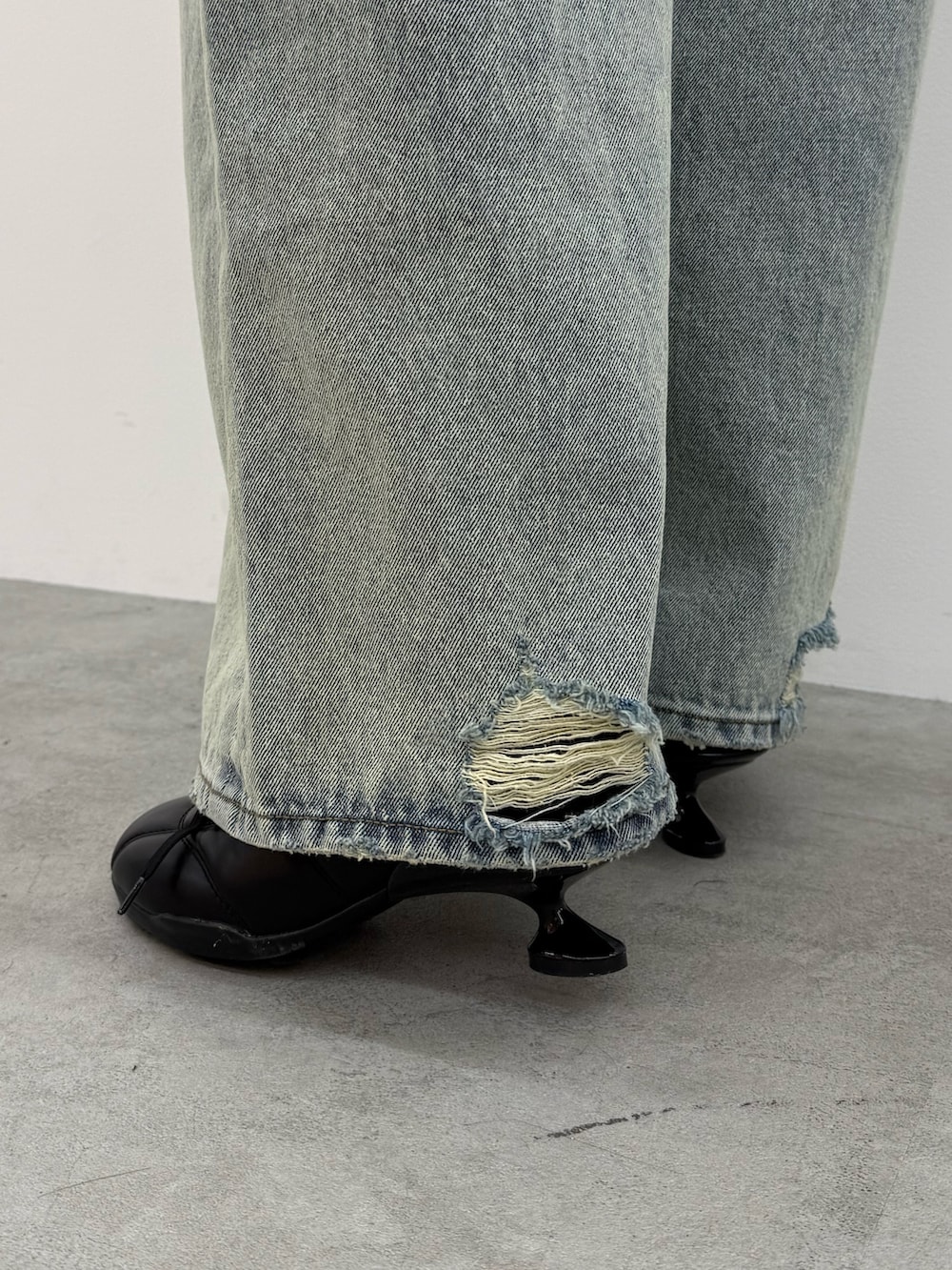 ブラック系のTシャツ/カットソー、ブルー系のデニムパンツ、ブラック系のスニーカーを着用したレディースの冬コーディネートの5枚目の写真