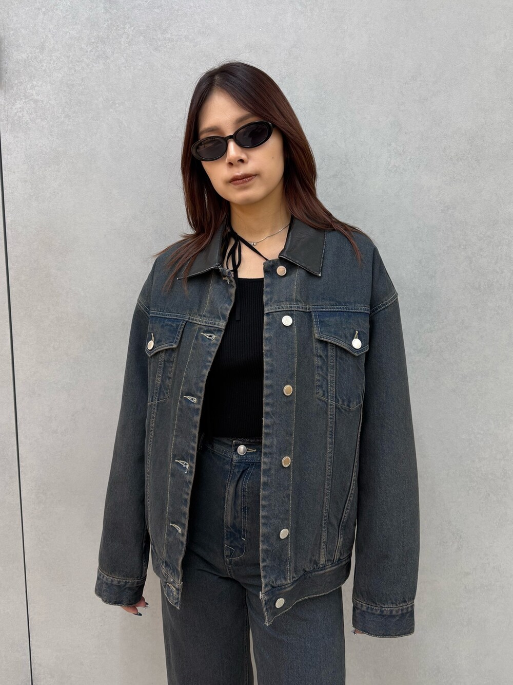 ブラック系のニット/セーター、ブルー系のブルゾン、ブルー系のデニムパンツを着用したレディースの冬コーディネートの4枚目の写真