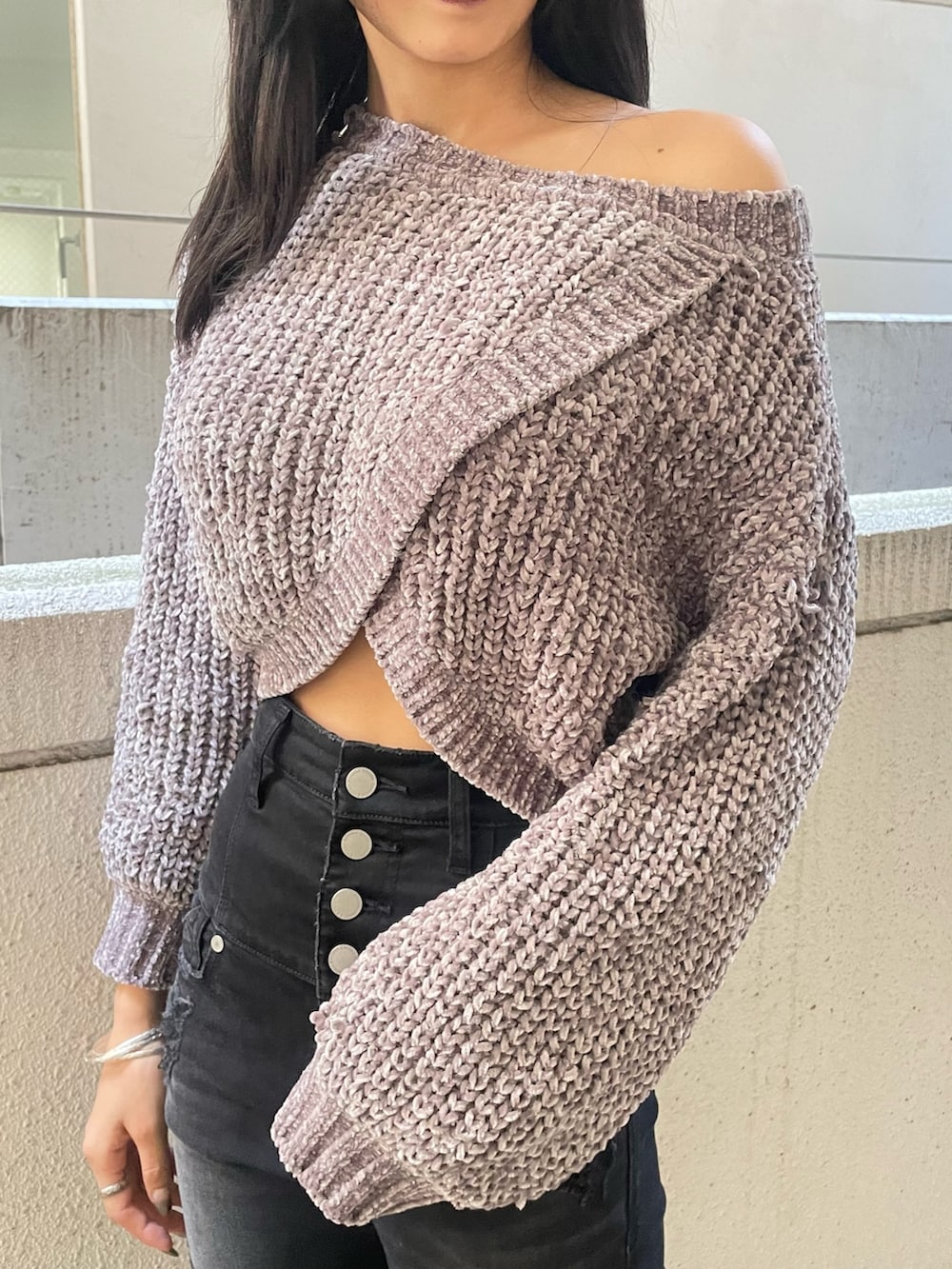 グレー系のニット/セーター、ブラック系のハンドバッグ、ブラック系のデニムパンツを着用したレディースの冬コーディネートの4枚目の写真