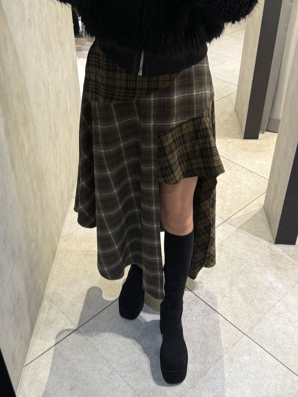 ブラック系のブルゾン、グリーン系のスカート、ブラック系のブーツを着用したレディースの秋コーディネートの6枚目の写真