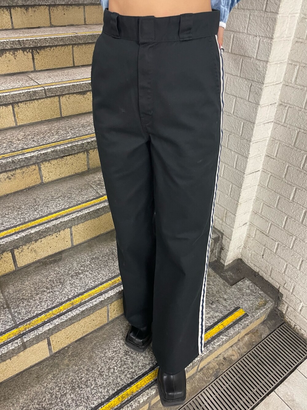 ブラック系のダウンベスト、ブルー系のTシャツ/カットソー、ブラック系のその他パンツを着用したレディースの秋コーディネートの9枚目の写真