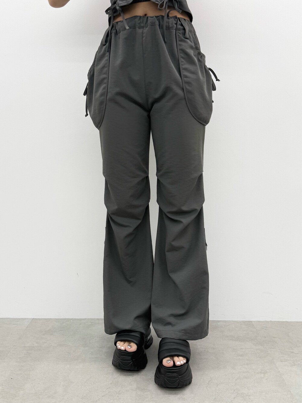 ブラック系のTシャツ/カットソー、グレー系のその他パンツ、ブラック系のハンドバッグを着用したレディースの夏コーディネートの7枚目の写真