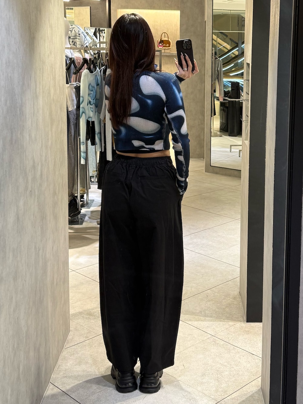 ブラック系のスニーカー、ブラック系のその他パンツ、ブルー系のニット/セーターを着用したレディースの春コーディネートの3枚目の写真