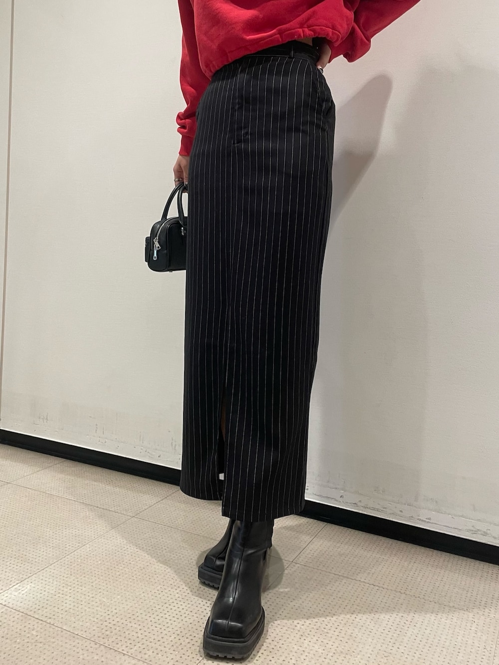 レッド系のスウェット、ブラック系のブルゾン、ブラック系のハンドバッグを着用したレディースの冬コーディネートの9枚目の写真