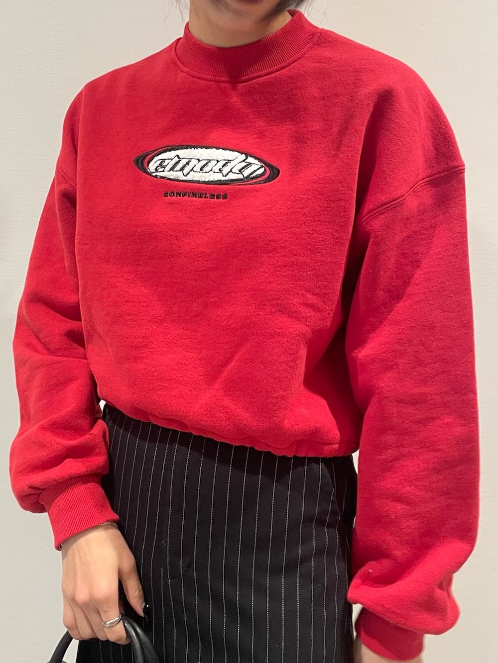 レッド系のスウェット、ブラック系のブルゾン、ブラック系のハンドバッグを着用したレディースの冬コーディネートの7枚目の写真