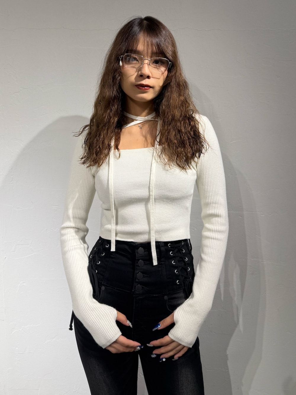 ホワイト系のニット/セーター、ブラック系のデニムパンツ、ブラック系のブーツを着用したレディースの秋コーディネートの4枚目の写真