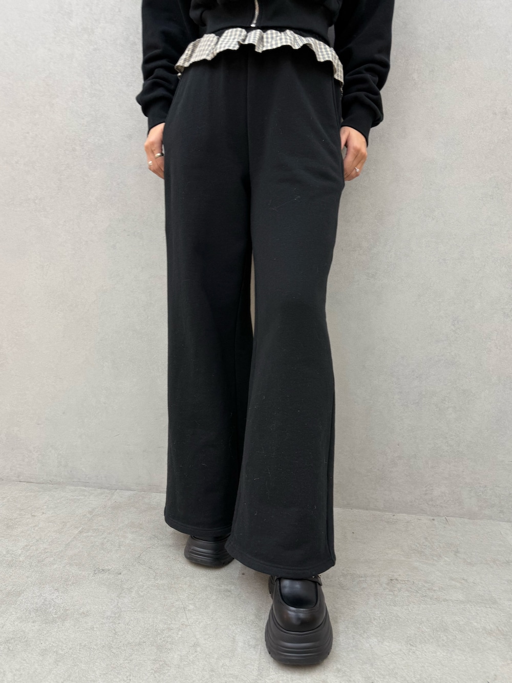 ブラック系のTシャツ/カットソー、ブラック系のスウェットパンツ、ブラック系のローファーを着用したレディースの冬コーディネートの5枚目の写真