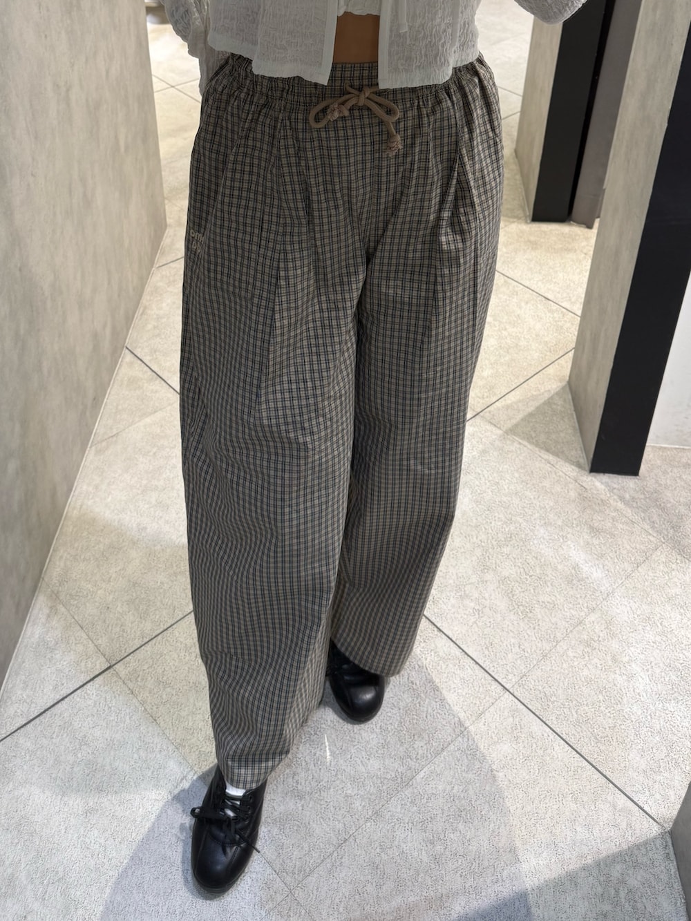 ホワイト系のTシャツ/カットソー、ベージュ系のその他パンツ、ブラック系のスニーカーを着用したレディースの春コーディネートの6枚目の写真