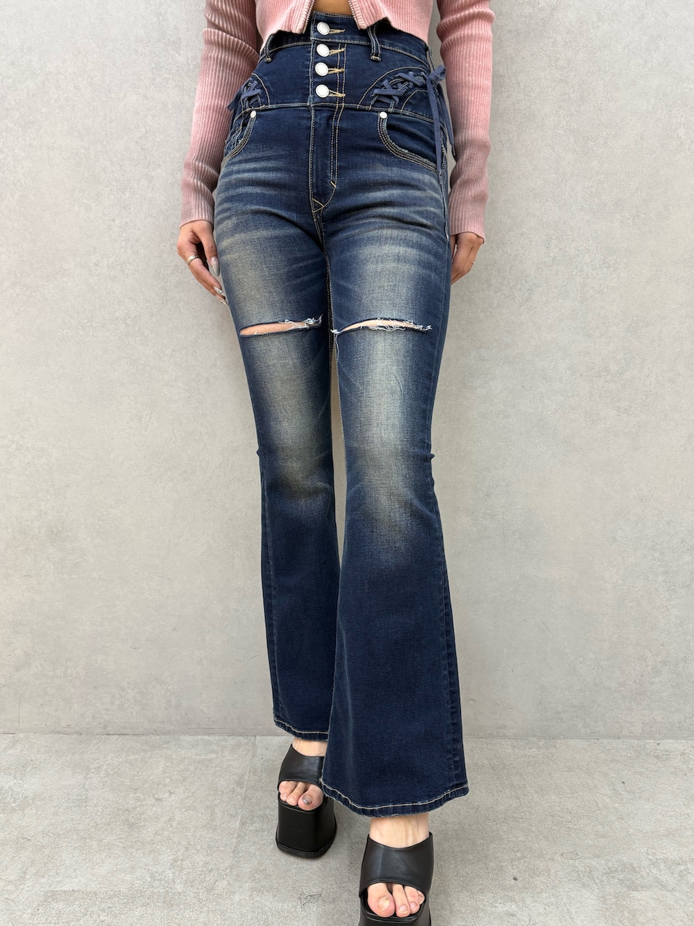 ピンク系のニット/セーター、ブルー系のデニムパンツ、ブラック系のサンダルを着用したレディースの冬コーディネートの5枚目の写真