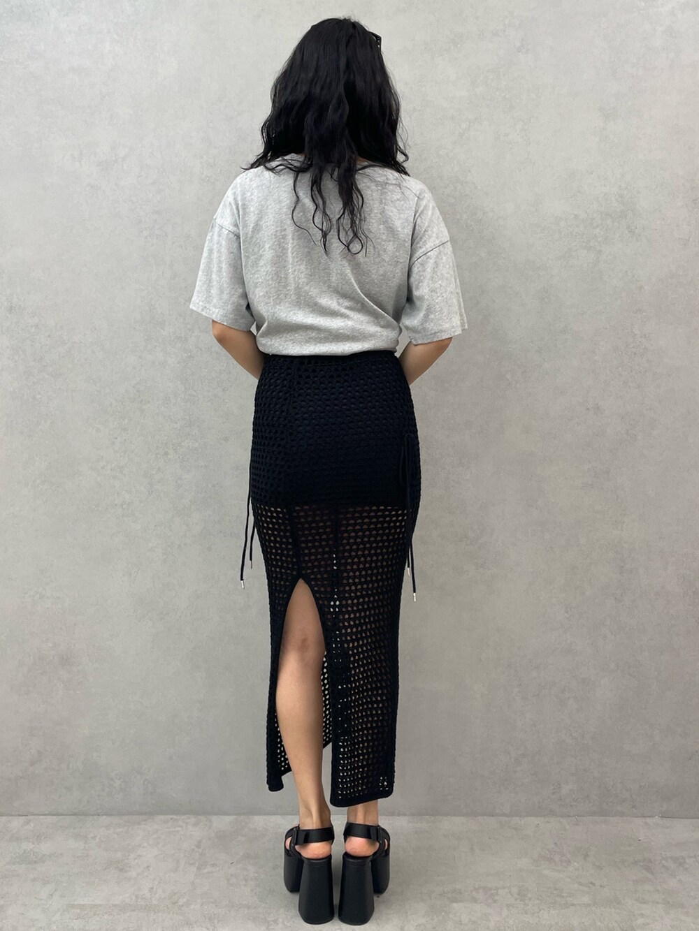 グレー系のTシャツ/カットソー、ブラック系のスカート、ブラック系のサンダルを着用したレディースの春コーディネートの3枚目の写真