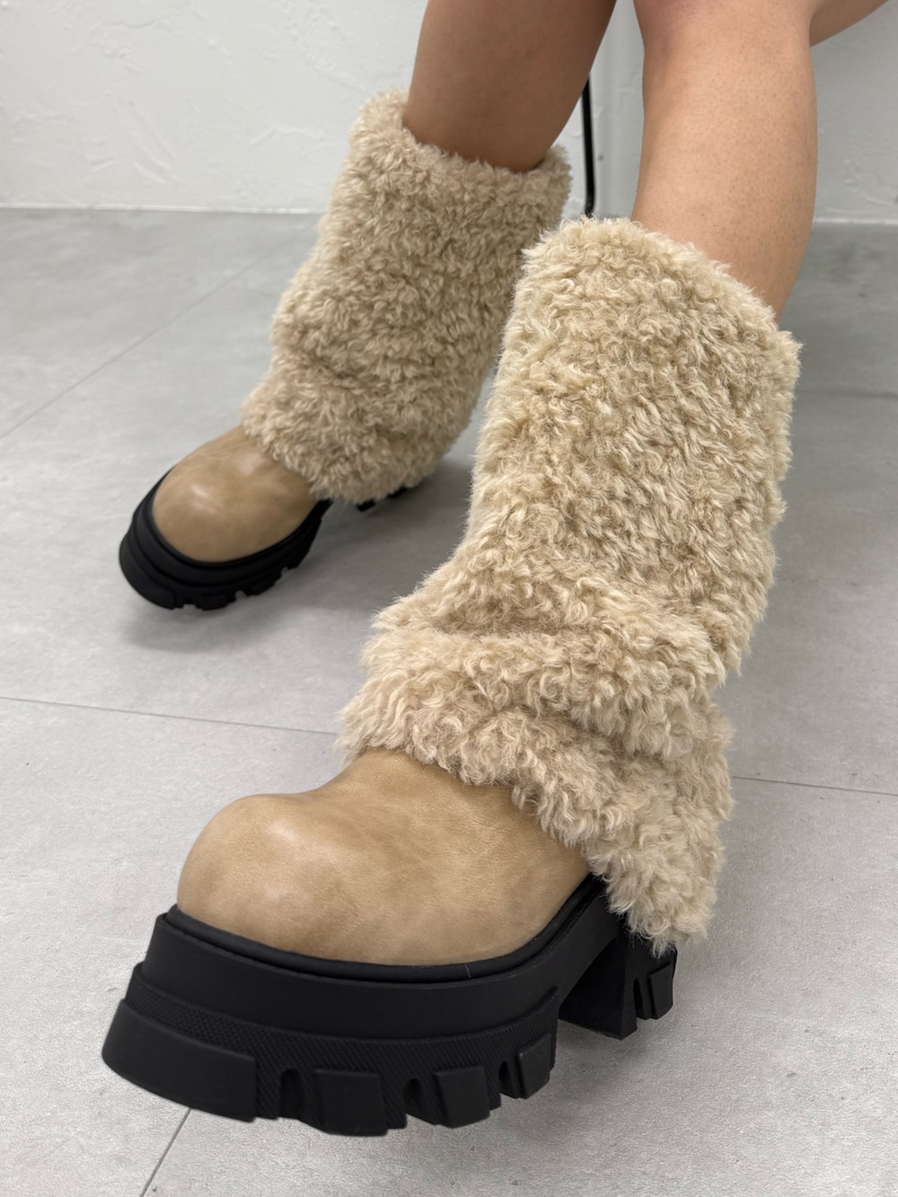 ベージュ系のニット/セーター、ブラック系のスカート、ホワイト系のブーツを着用したレディースの冬コーディネートの5枚目の写真