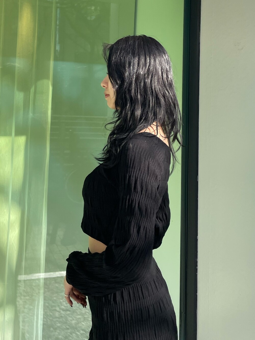 ブラック系のニット/セーター、ブラック系のスカート、ブラック系のブーツを着用したレディースの春コーディネートの5枚目の写真