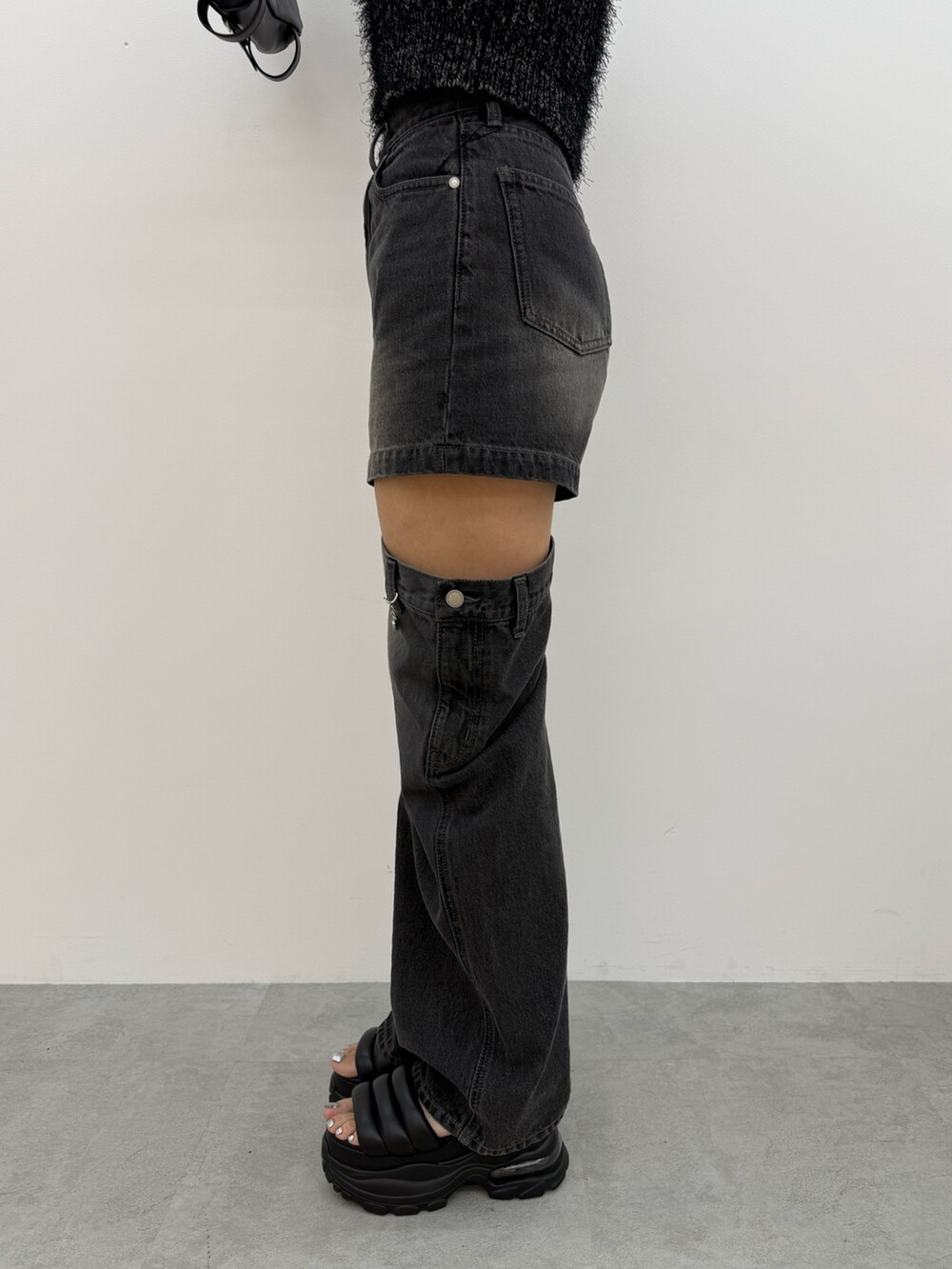 ブラック系のニット/セーター、ブラック系のデニムパンツ、ブラック系のサンダルを着用したレディースの夏コーディネートの8枚目の写真