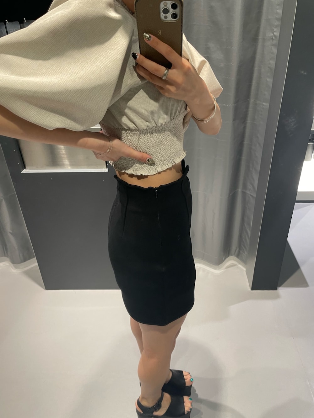 ブルー系のTシャツ/カットソー、ブラック系のスカート、シルバー系のハンドバッグを着用したレディースの夏コーディネートの7枚目の写真