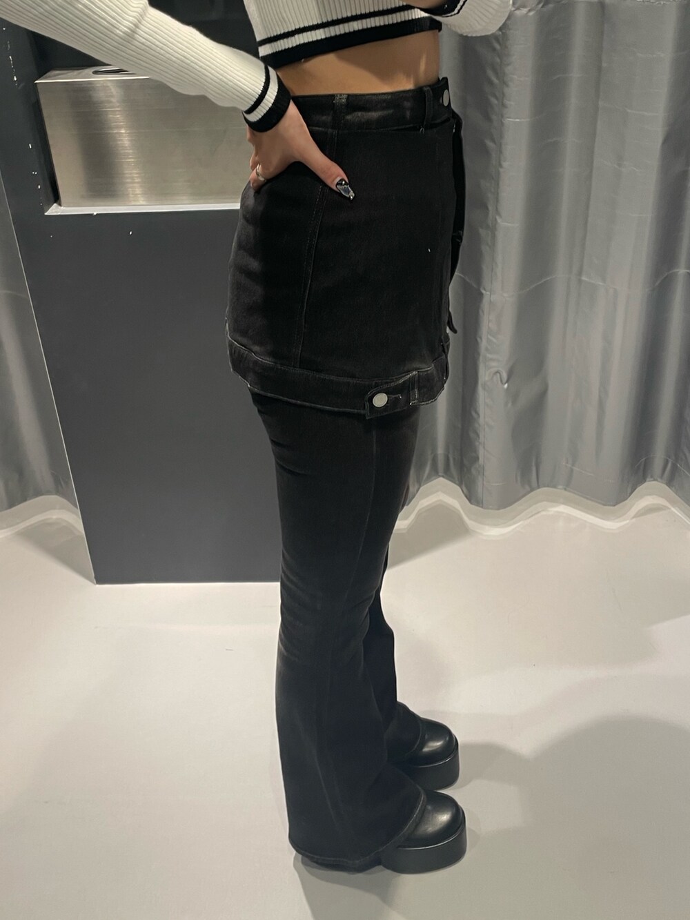 ホワイト系のニット/セーター、ブラック系のデニムパンツ、ブラック系のブーツを着用したレディースの秋コーディネートの7枚目の写真