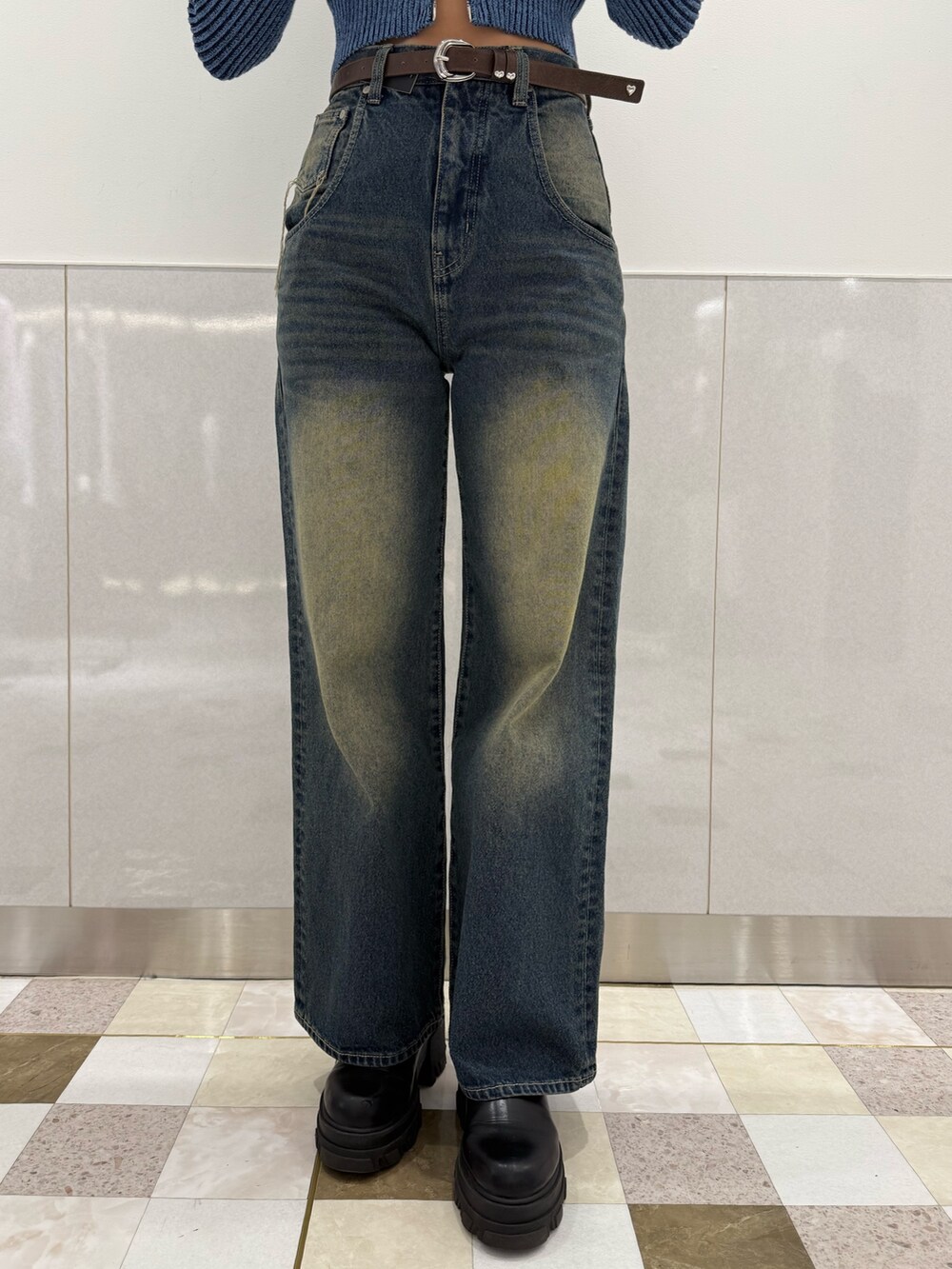 ブルー系のニット/セーター、ブルー系のデニムパンツ、ブラック系のブーツを着用したレディースの冬コーディネートの6枚目の写真