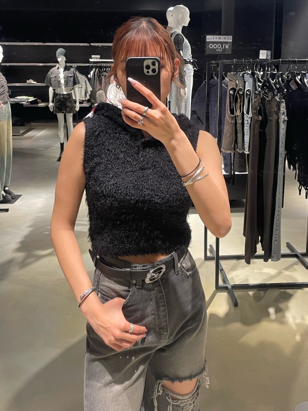 ブラック系のニット/セーター、ブラック系のデニムパンツ、ブラック系のパンプスを着用したレディースの春コーディネートの4枚目の写真