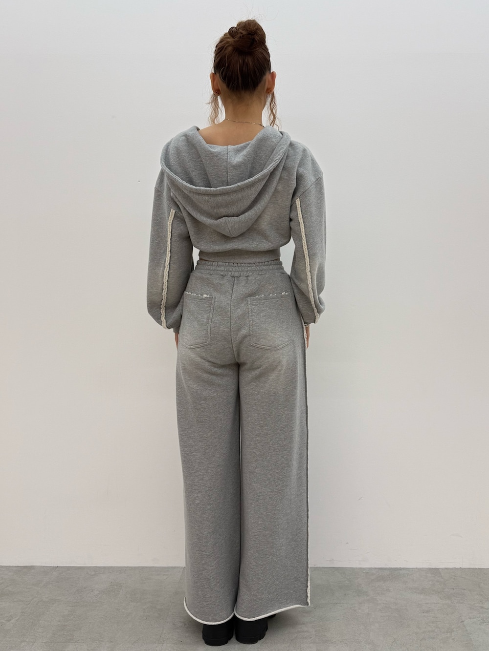 グレー系のパーカー、ブラック系のキャミソール、グレー系のスウェットパンツを着用したレディースの夏コーディネートの3枚目の写真