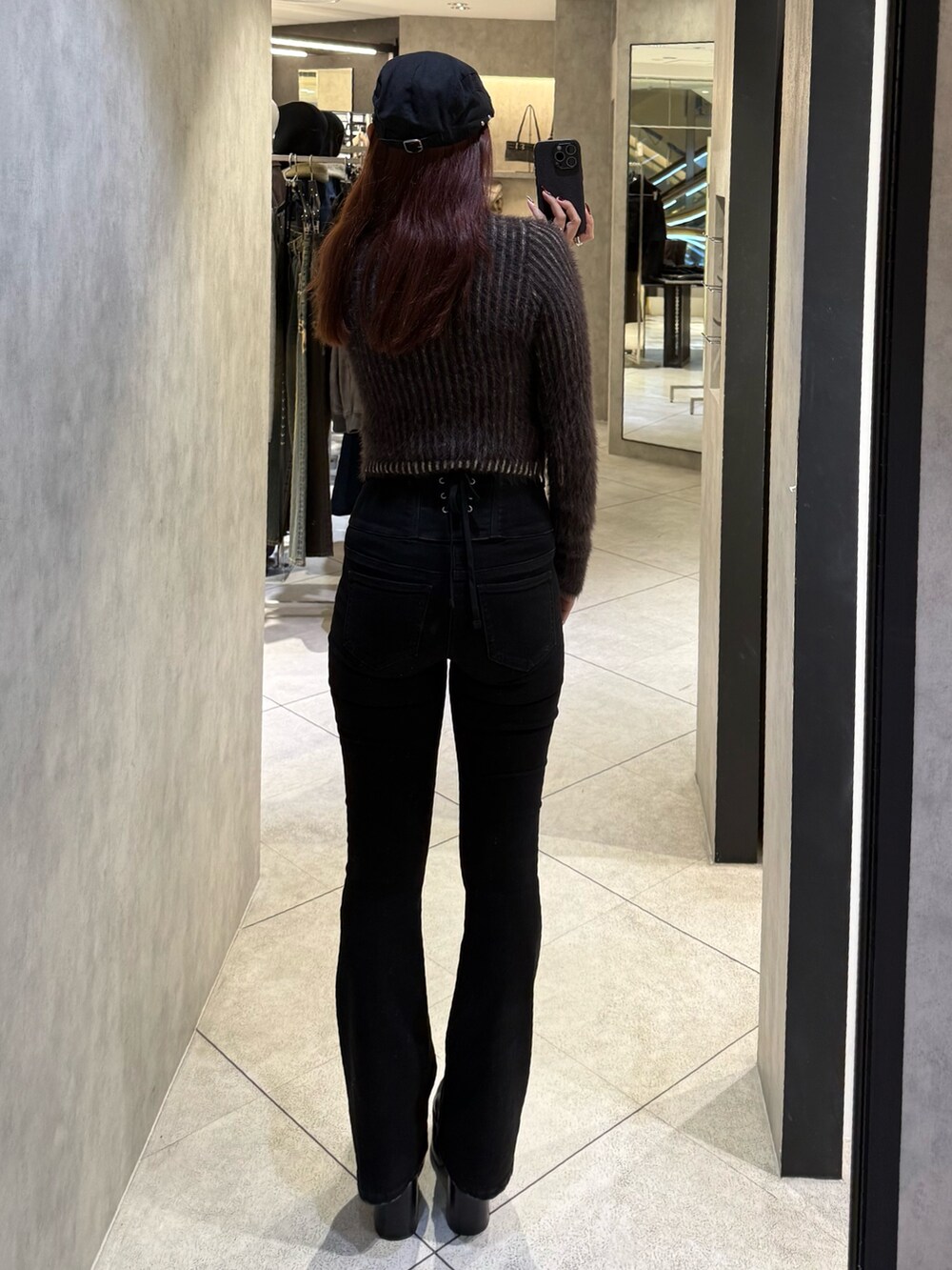 ブラウン系のニット/セーター、ブラック系のデニムパンツ、ブラック系のブーツを着用したレディースの秋コーディネートの3枚目の写真