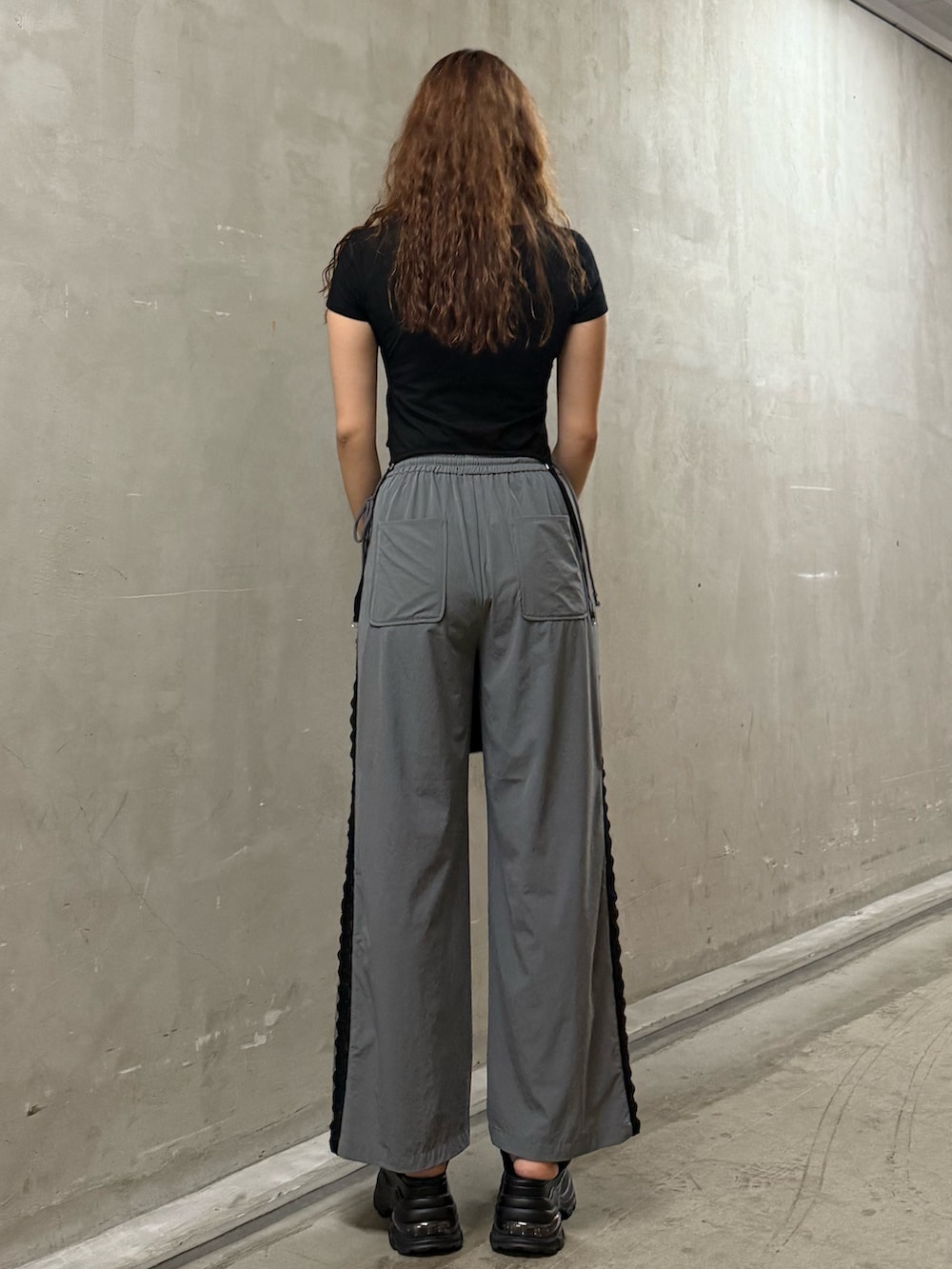 ブラック系のTシャツ/カットソー、グレー系のその他パンツ、ブラック系のハンドバッグを着用したレディースの夏コーディネートの3枚目の写真