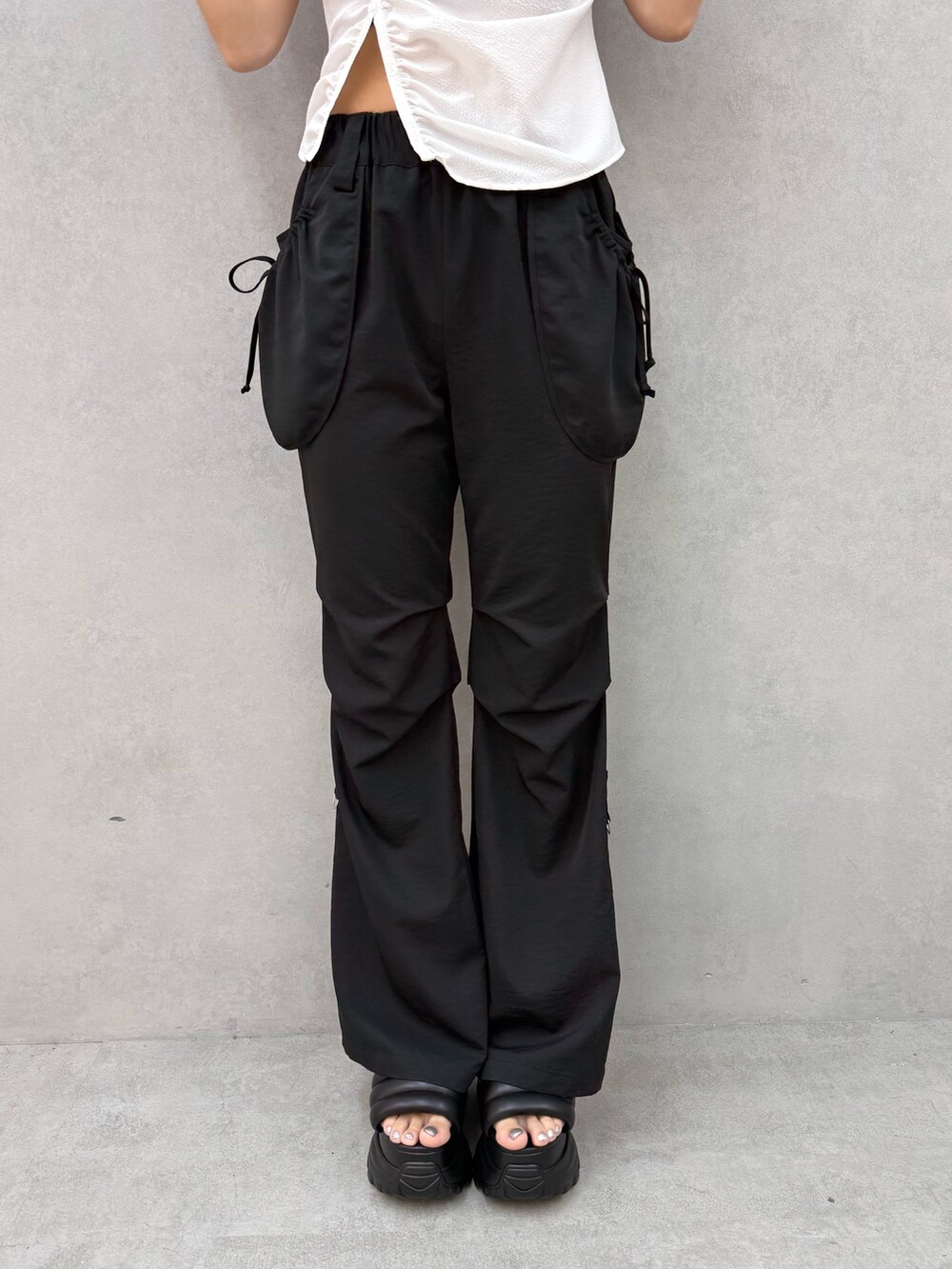 ホワイト系のTシャツ/カットソー、ブラック系のその他パンツ、ブラック系のサンダルを着用したレディースの夏コーディネートの7枚目の写真