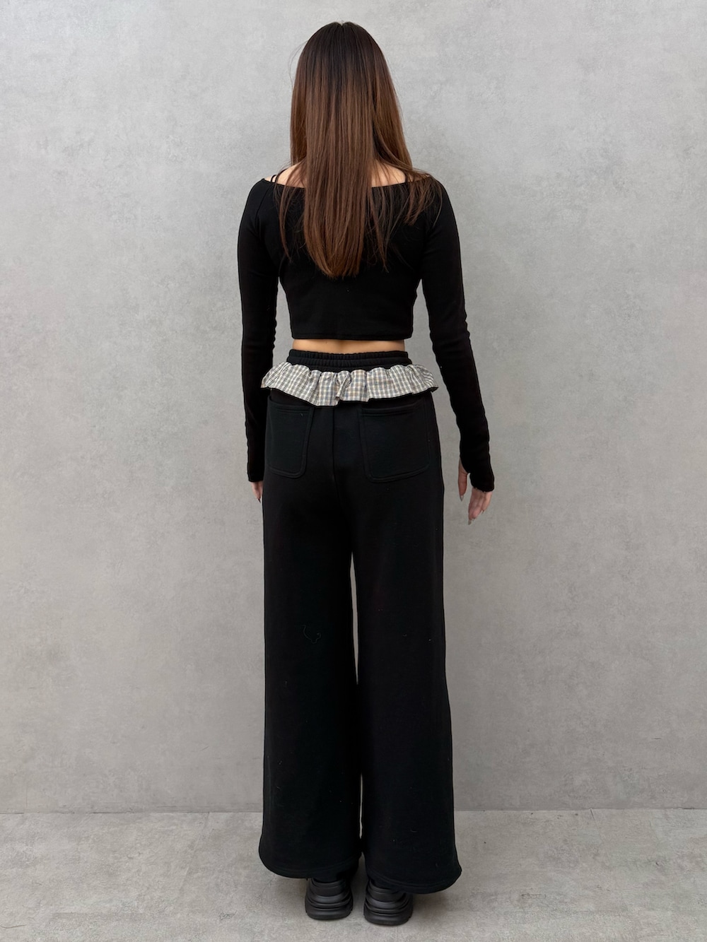 ブラック系のTシャツ/カットソー、ブラック系のスウェットパンツ、ブラック系のローファーを着用したレディースの冬コーディネートの3枚目の写真