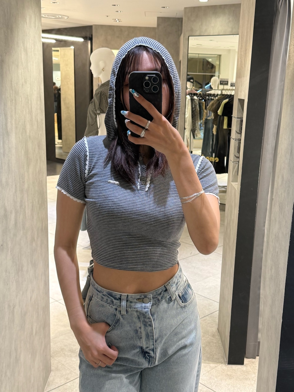 グレー系のTシャツ/カットソー、ブルー系のデニムパンツ、ブラック系のスニーカーを着用したレディースの春コーディネートの4枚目の写真