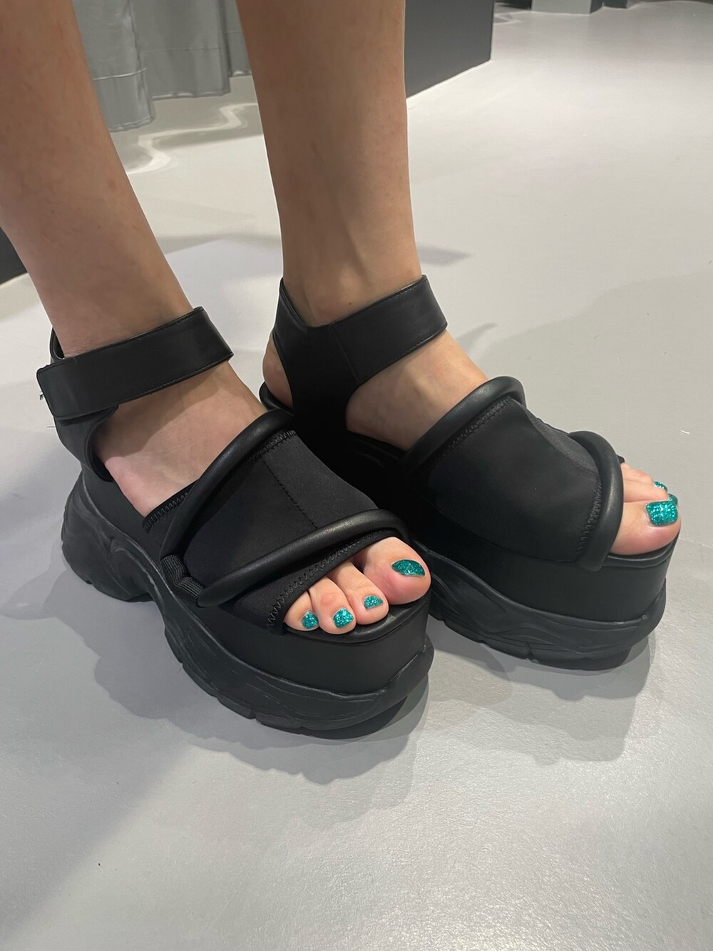 ブラック系のニット/セーター、グレー系のスカート、ブラック系のショルダーバッグを着用したレディースの夏コーディネートの9枚目の写真