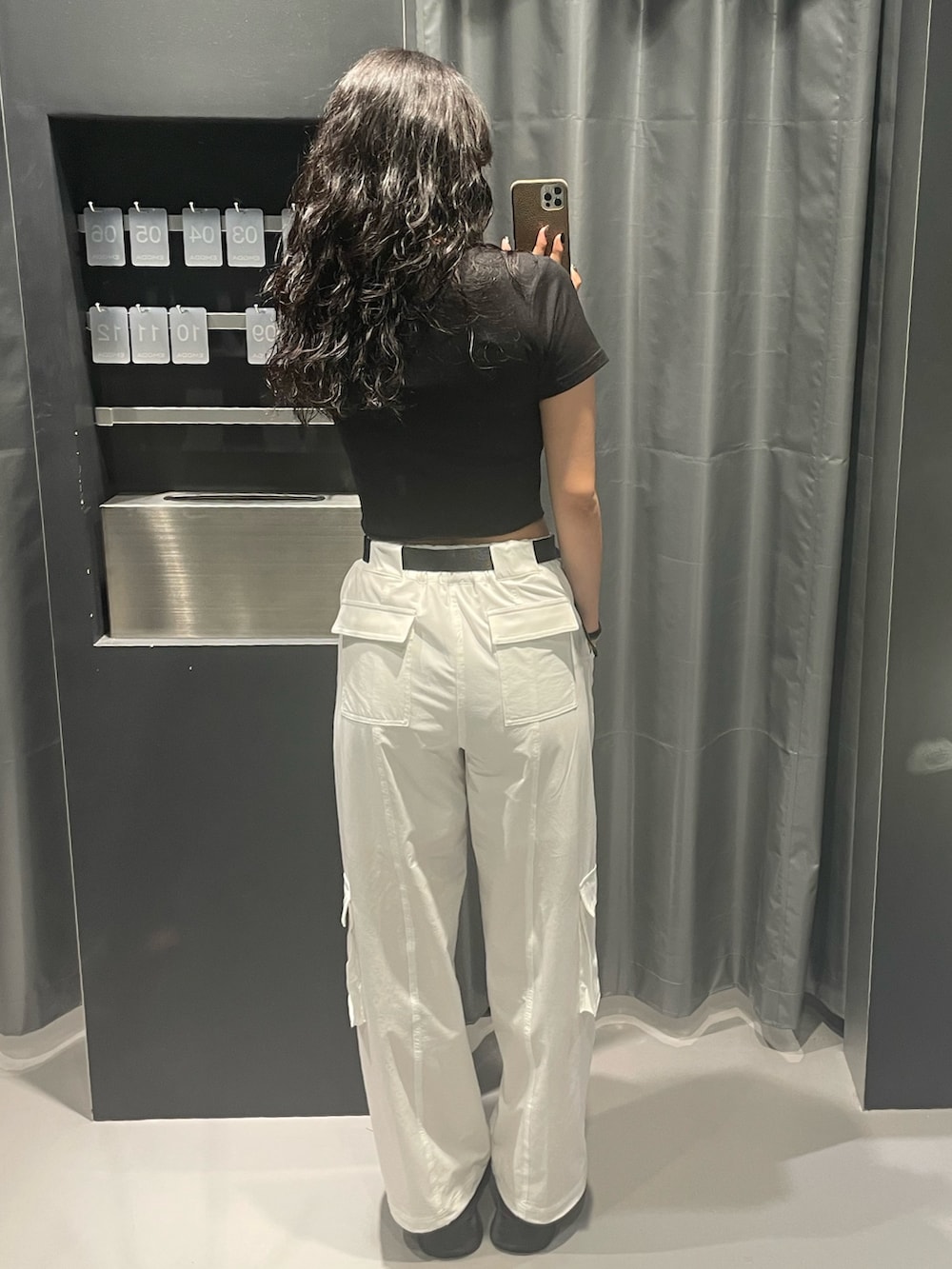 ブラック系のTシャツ/カットソー、ホワイト系のカーゴパンツ、ブラック系のサンダルを着用したレディースの夏コーディネートの3枚目の写真