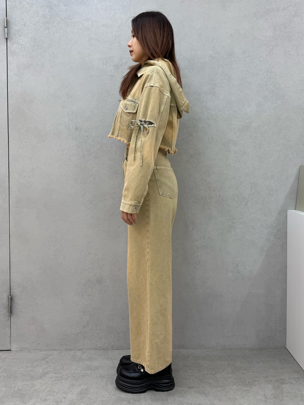 ベージュ系のデニムジャケット、ホワイト系のTシャツ/カットソー、ベージュ系のデニムパンツを着用したレディースの冬コーディネートの2枚目の写真