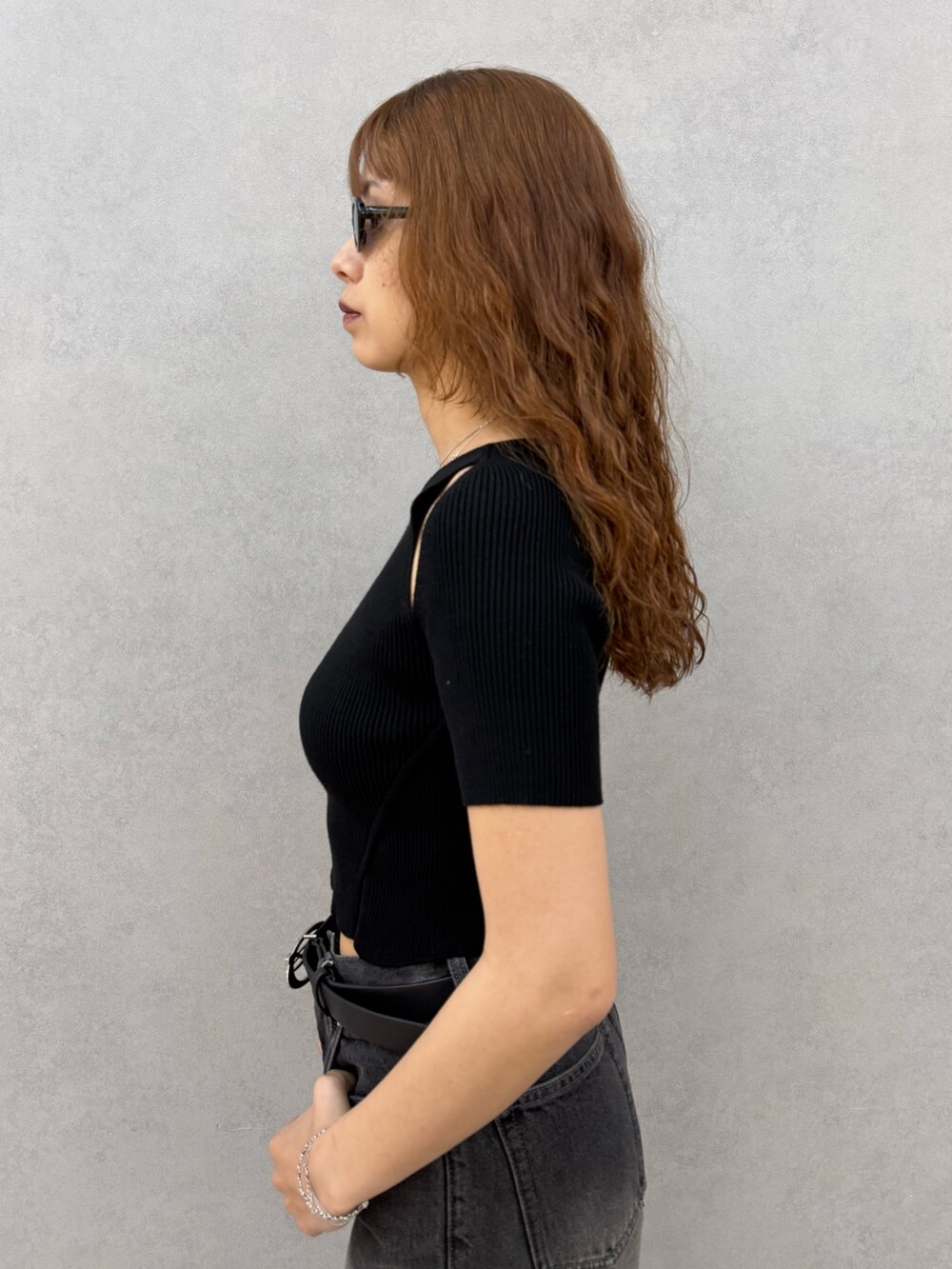 ブラック系のニット/セーター、ブラック系のデニムパンツ、ブラック系のサンダルを着用したレディースの夏コーディネートの5枚目の写真