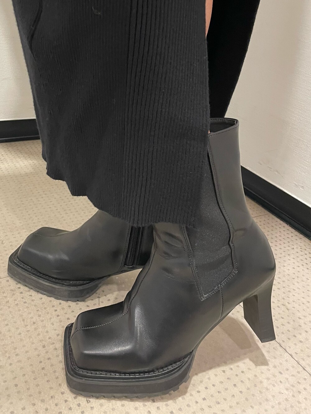 レッド系のスウェット、ブラック系のブルゾン、ブラック系のハンドバッグを着用したレディースの冬コーディネートの10枚目の写真