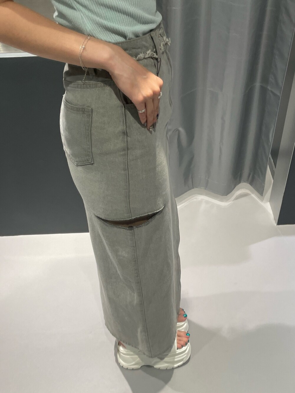 ブルー系のTシャツ/カットソー、グレー系のデニムスカート、ホワイト系のサンダルを着用したレディースの夏コーディネートの7枚目の写真