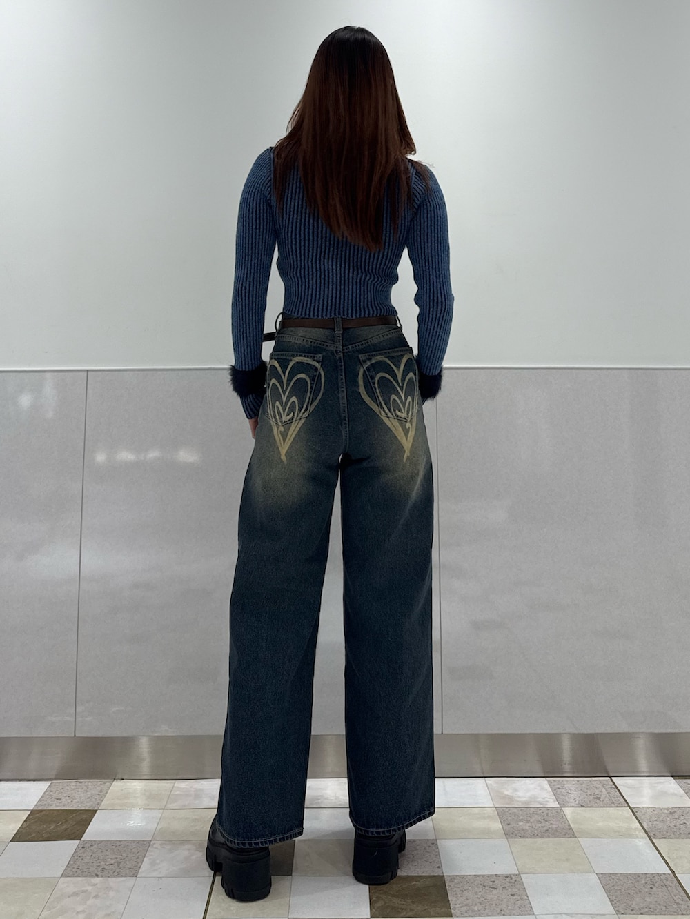 ブルー系のニット/セーター、ブルー系のデニムパンツ、ブラック系のブーツを着用したレディースの冬コーディネートの3枚目の写真