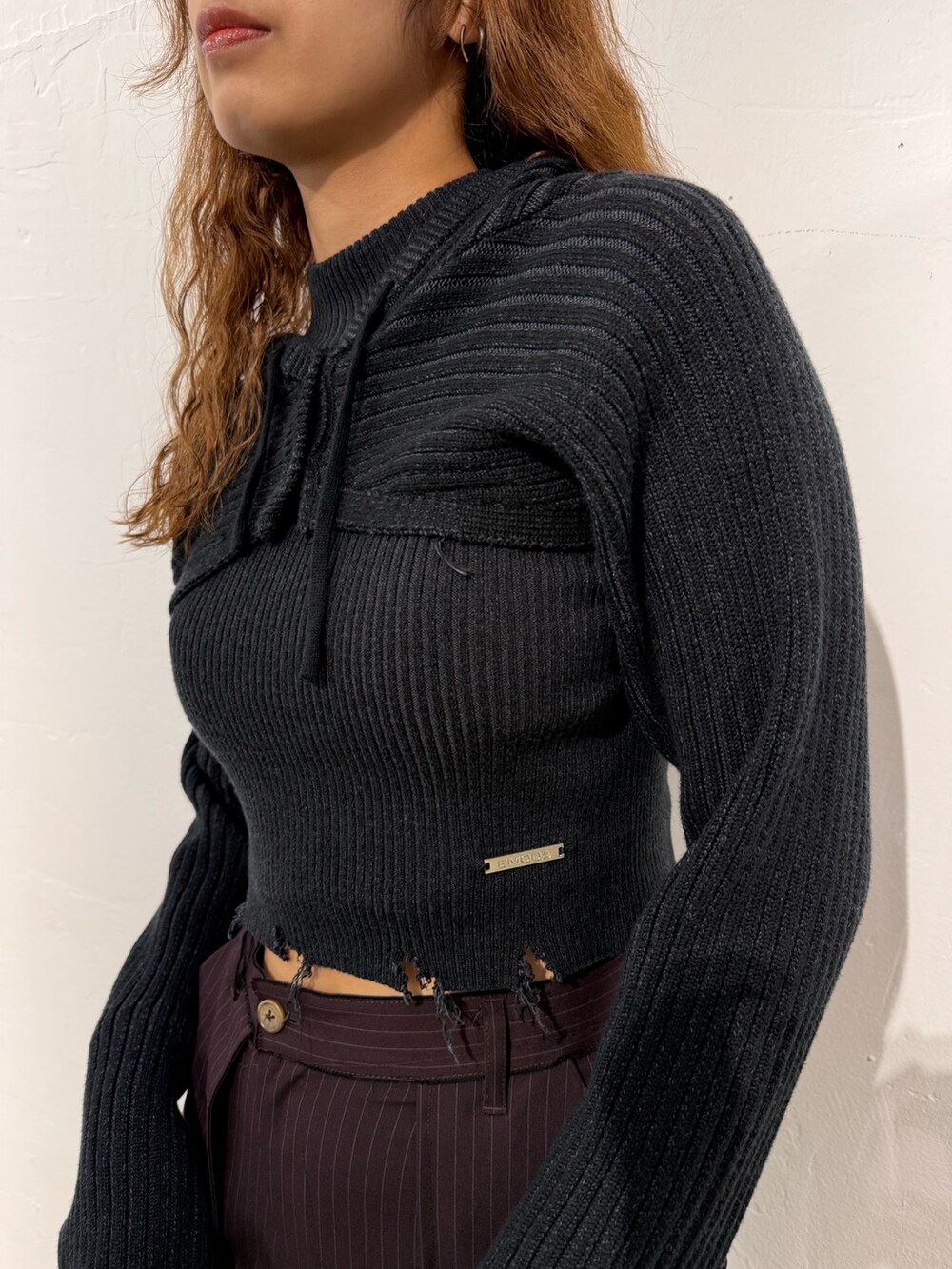 ブラック系のニット/セーター、ブラウン系のその他パンツ、ブラック系のハンドバッグを着用したレディースの秋コーディネートの4枚目の写真