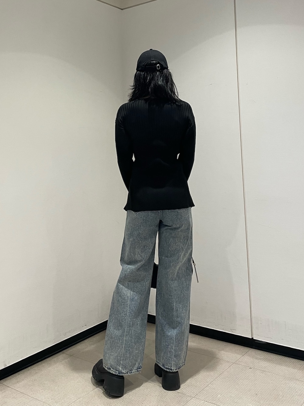 ブラック系のニット/セーター、ブルー系のデニムパンツ、ブラック系のハンドバッグを着用したレディースの冬コーディネートの3枚目の写真