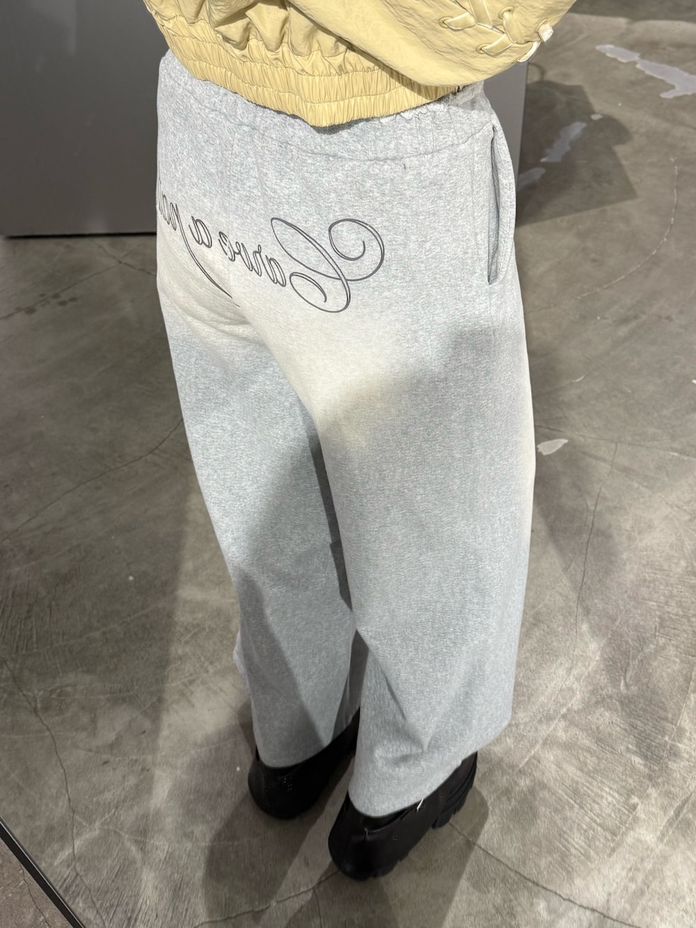 ホワイト系のTシャツ/カットソー、イエロー系のブルゾン、グレー系のスウェットパンツを着用したレディースの春コーディネートの6枚目の写真