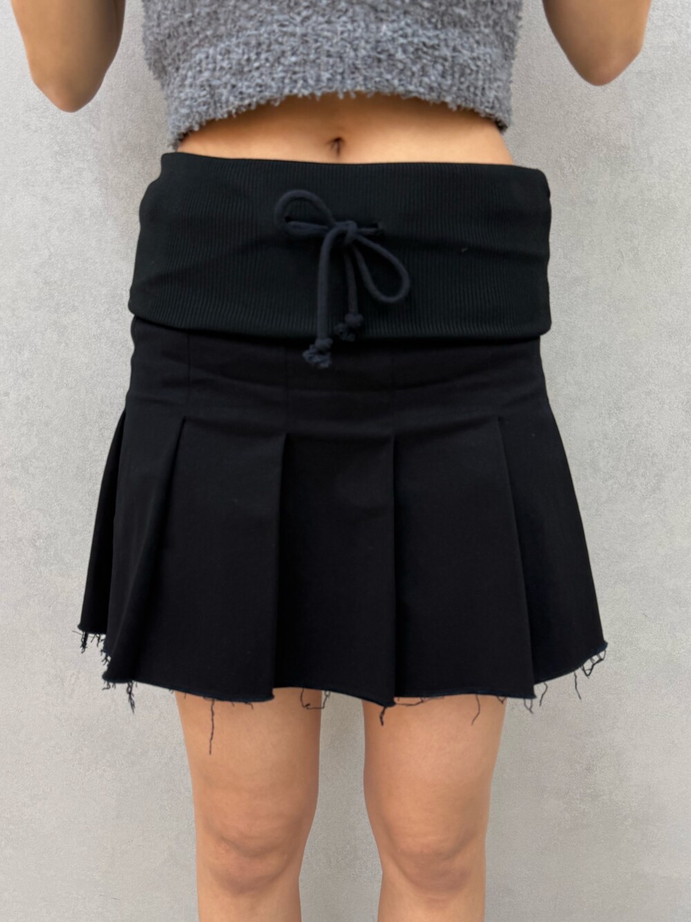 ブラック系のスカート、ブラック系のサンダル、グレー系のニット/セーターを着用したレディースの夏コーディネートの7枚目の写真